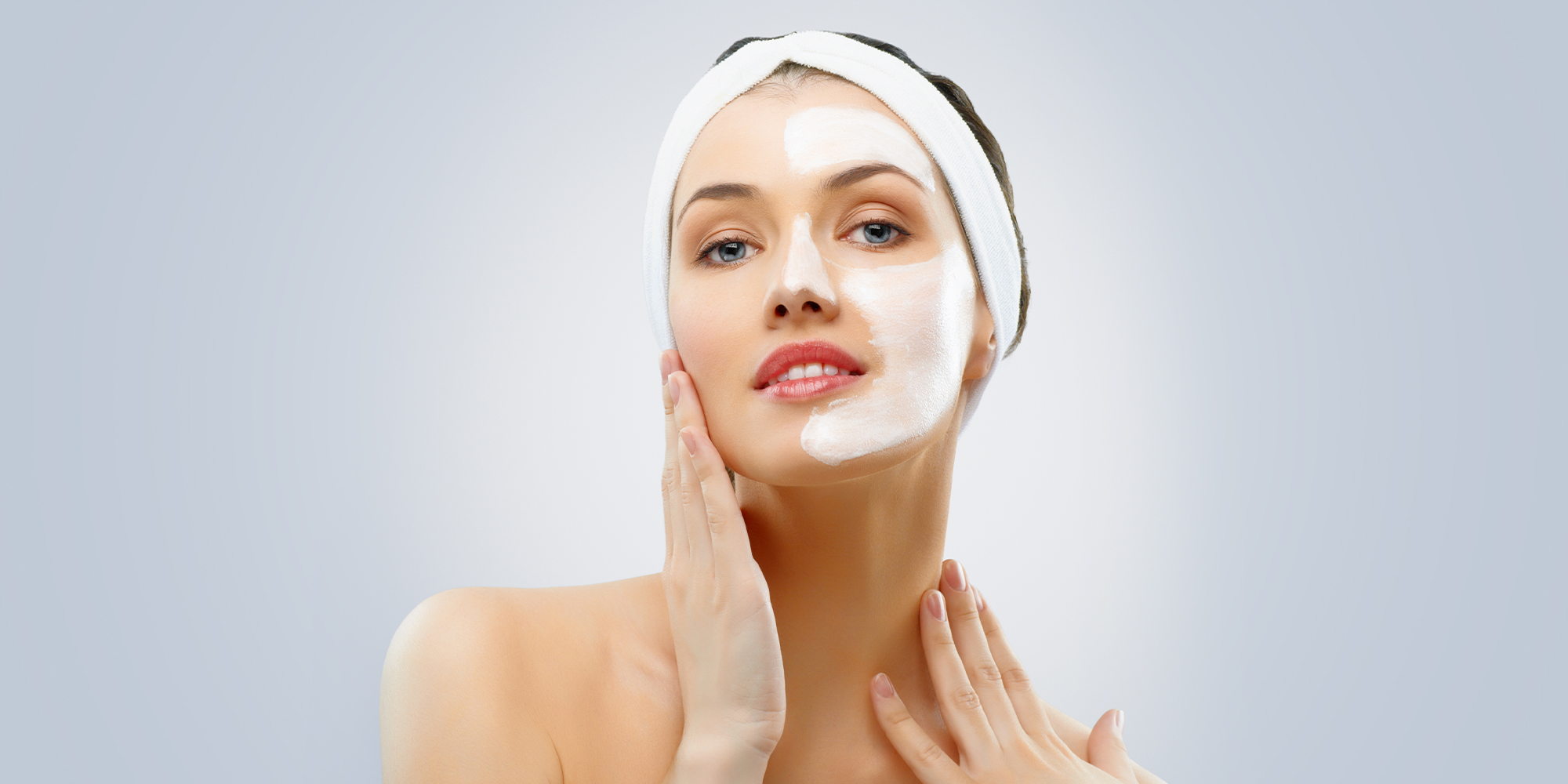 woman with half her face done in a cleansing mask
